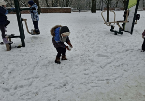 Zdjęcie przedstawia dzieci podczas zabaw na śniegu