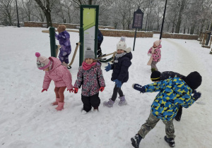 Zdjęcie przedstawia dzieci podczas zabaw na śniegu