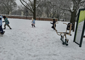 Zdjęcie przedstawia dzieci podczas zabaw na śniegu