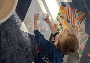 Zdjęcie przedstawia dzieci podczas zabaw ze śniegiem