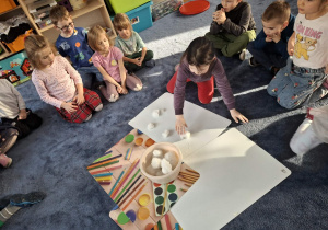 Zdjęcie przedstawia dzieci podczas zabaw ze śniegiem