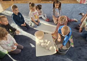 Zdjęcie przedstawia dzieci podczas zabaw ze śniegiem