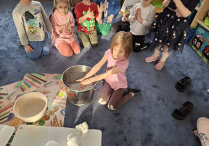 Zdjęcie przedstawia dzieci podczas zabaw ze śniegiem