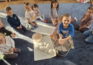 Zdjęcie przedstawia dzieci podczas zabaw ze śniegiem