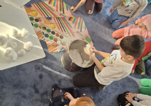 Zdjęcie przedstawia dzieci podczas zabaw ze śniegiem