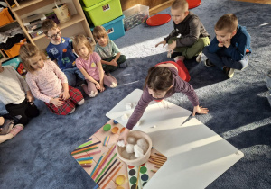 Zdjęcie przedstawia dzieci podczas zabaw ze śniegiem