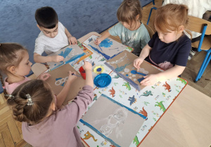 Zdjęcie przedstawia dzieci podczas zabaw ze śniegiem