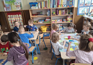 Zdjęcie przedstawia dzieci podczas zabaw ze śniegiem