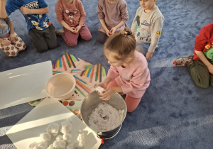 Zdjęcie przedstawia dzieci podczas zabaw ze śniegiem