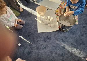 Zdjęcie przedstawia dzieci podczas zabaw ze śniegiem