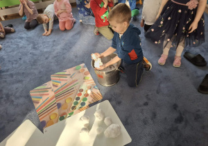 Zdjęcie przedstawia dzieci podczas zabaw ze śniegiem