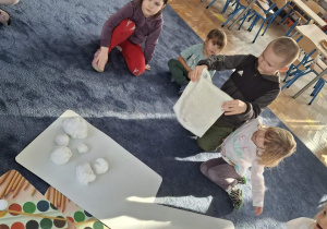 Zdjęcie przedstawia dzieci podczas zabaw ze śniegiem