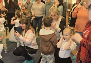 Zdjęcie przedstawia dzieci tańczące z dziadkami