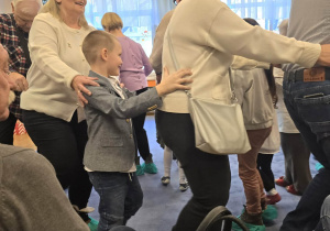 Zdjęcie przedstawia dzieci tańczące z dziadkami