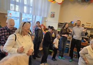 Zdjęcie przedstawia dzieci tańczące z dziadkami