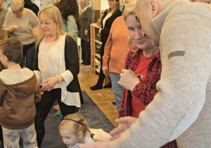 Zdjęcie przedstawia dzieci tańczące z dziadkami