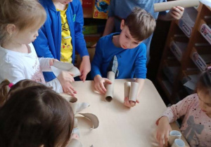 Zdjęcie przedstawia dzieci bawiące się materiałami z recyklingu