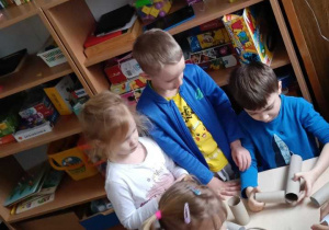 Zdjęcie przedstawia dzieci bawiące się materiałami z recyklingu