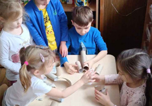 Zdjęcie przedstawia dzieci bawiące się materiałami z recyklingu