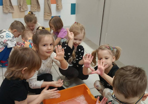 Zdjęcie przedstawia dzieci bawiące się w wodzie różnymi masami