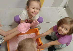 Zdjęcie przedstawia dzieci bawiące się w wodzie różnymi masami