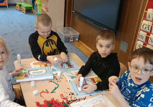 Zdjęcie przedstawia dzieci podczas nauki liter