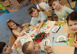 Zdjęcie przedstawia dzieci podczas nauki liter