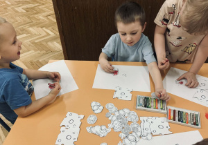 Zdjęcie przedstawia dzieci, które robią papierową pizze