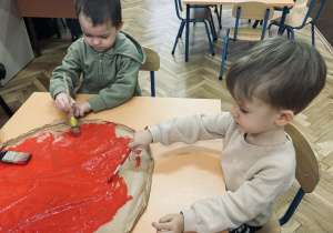 Zdjęcie przedstawia dzieci, które robią papierową pizze