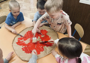 Zdjęcie przedstawia dzieci, które robią papierową pizze