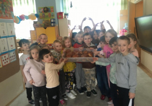 Zdjęcie przedstawia dzieci z pączkami