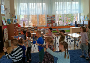 Dzieci ćwiczące układ taneczny przy tablicy multimedialnej