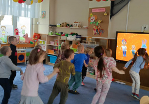 Dzieci ćwiczące układ taneczny przy tablicy multimedialnej