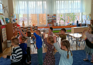 Dzieci ćwiczące układ taneczny przy tablicy multimedialnej