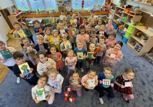 Zdjęcie przedstawia dzieci z kartkami z okazji dnia kobiet