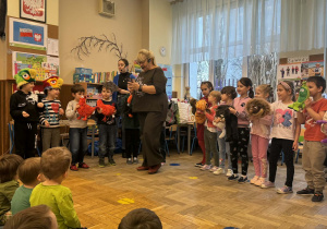 Zdjęcie przedstawia dzieci w trakcie koncertu muzycznego