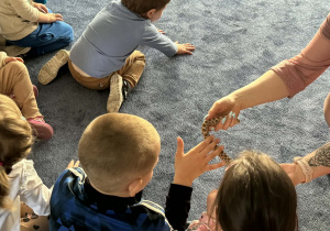 Zdjęcie przedstawia dzieci w trakcie spotkania ze zwierzętami