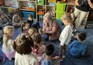 Zdjęcie przedstawia dzieci w trakcie spotkania ze zwierzętami