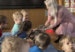 Zdjęcie przedstawia dzieci w trakcie spotkania ze zwierzętami