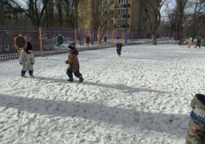 Zdjęcie przedstawia dzieci w trakcie zabaw na sniegu