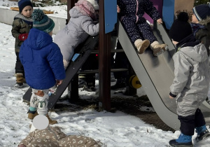 Zdjęcie przedstawia dzieci w trakcie zabaw na sniegu