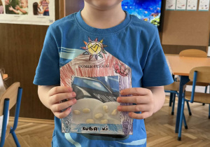 Zdjęcie przedstawia dziecko z domkiem dla fasolek