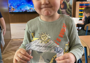 Zdjęcie przedstawia dziecko z domkiem dla fasolek