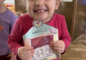 Zdjęcie przedstawia dziecko z domkiem dla fasolek