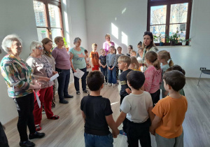 Dzieci ustawione w okręgu z przedstawicielami fundacji