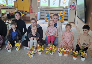 Dzieci i rodzice prezentujący wykonane wspólnie stroiki wielkanocne