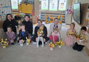 Dzieci i rodzice prezentujący wykonane wspólnie stroiki wielkanocne