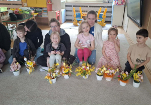 Dzieci i rodzice prezentujący wykonane wspólnie stroiki wielkanocne