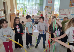 Dzieci podczas zabaw ruchowych z użyciem szarf i wstążek