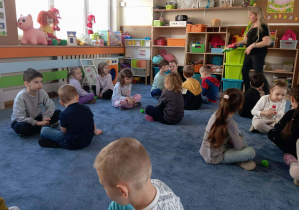 Dzieci siedzące na dywanie w parach podczas zajęć